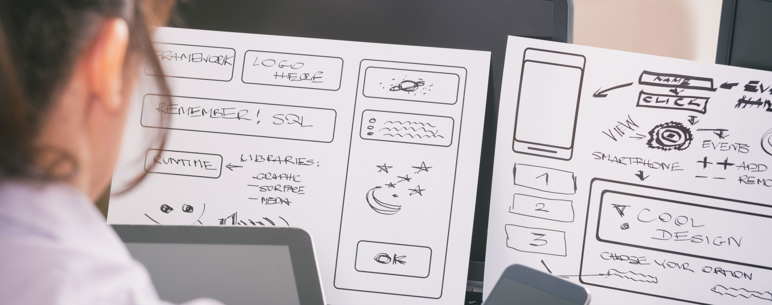 Hand-drawn wireframes of initial sketches of a user interface design. The wireframes show layout, structure, and basic elements of an interface.